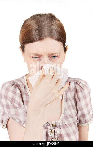 Young pale girl having a cold sneezing and whipping nose with paper tissue Stock Photo