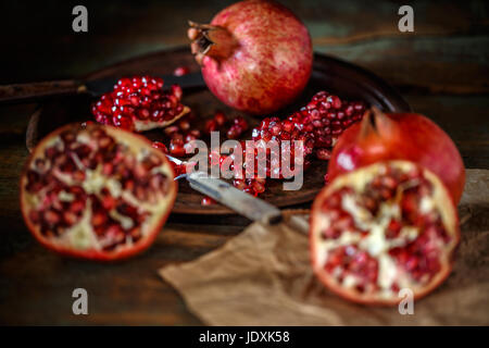 Fresh juicy pomegranate, whole and cut  on vintage background Stock Photo