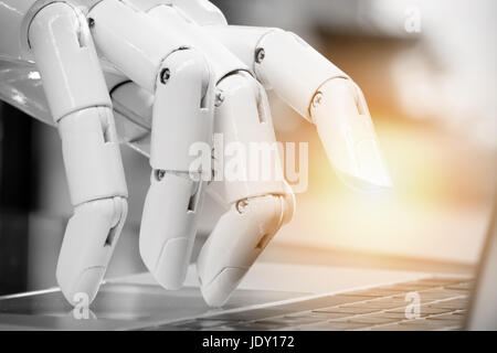 Robotic , artificial intelligence , robo advisor , chatbot concept. Robot finger point to laptop button with flare light effect. Stock Photo