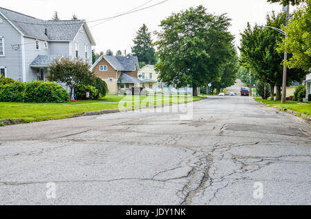 Kane, USA - July 21, 2014: Residential neighborhood in city with rough roads and streets and houses Stock Photo