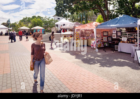 License available at MaximImages.com - Young woman walking past farmer's market vendors at Pioneer Waterfront Plaza in downtown Nanaimo, Vancouver Isl Stock Photo