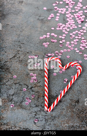Christmas decorations - candy canes and sequins over dark background Stock Photo