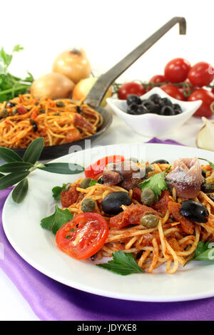 Capellini mit Tomaten, Sardellen, Kapern und Oliven Stock Photo
