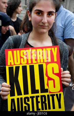 London, UK. 21st June, 2017. Day of rage protest after the fire at Grenfell House, West London. A woman holds a placard which says 'Austerity kills'. Credit: Jenny Matthews/Alamy Live News Stock Photo