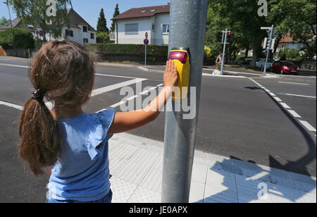 Neu-Ulm, Germany. 22nd June, 2017. Littel Tara presses a button at an intersection in Neu-Ulm, Germany, 22 June 2017. The voice declarding: "Thank you, it will be green in a moment" can be then heard from a speaker. The speaking traffic lights are supposed to lower traffic risks for children. Photo: Karl-Josef Hildenbrand/dpa/Ģ����ý Live News Stock Photo