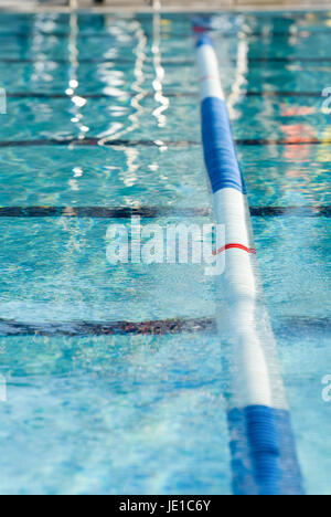 Picture of a lane line in a outdoor swimming pool. Focus centered on the red stripe on the lane line Stock Photo