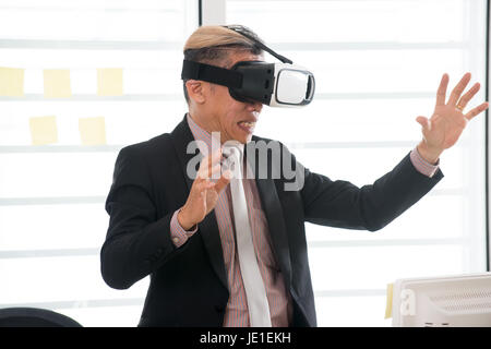 Businessman making gestures when wearing virtual reality goggles Stock Photo