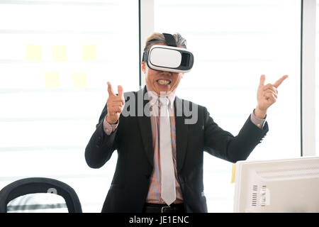 Businessman making gestures when wearing virtual reality goggles Stock Photo