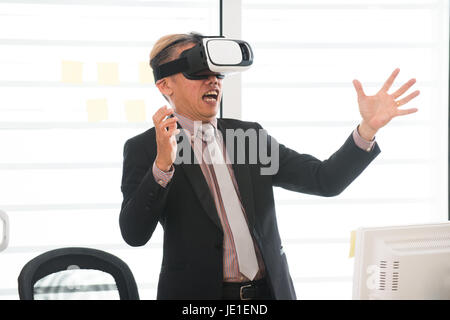 Businessman making gestures when wearing virtual reality goggles Stock Photo