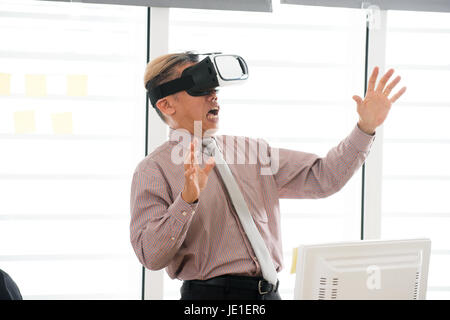 Businessman making gestures when wearing virtual reality goggles Stock Photo