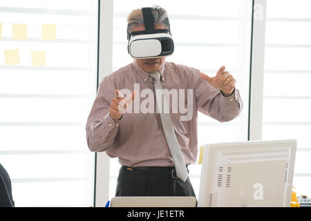 Businessman making gestures when wearing virtual reality goggles Stock Photo
