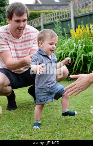 One year old baby boy taking first steps Stock Photo