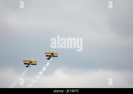 Two Blue and Yellow Biplanes Flying Together Upwards Stock Photo
