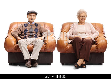 Seniors sitting in leather armchairs and looking at the camera isolated on white background Stock Photo