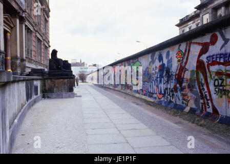 Looking down the Berlin Wall with 2 buildings close together divided by the wall, 1987 Stock Photo