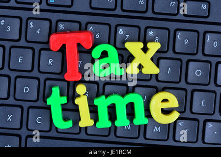 Tax time words on computer keyboard closeup Stock Photo