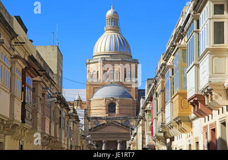 Traditional houses with balconies dome of Paola parish church, Tarxien town, near Valletta, Malta Stock Photo