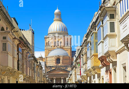 Traditional houses with balconies dome of Paola parish church, Tarxien town, near Valletta, Malta Stock Photo