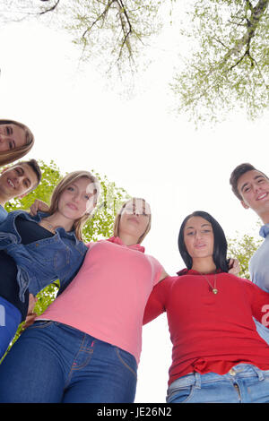 Happy smiling group of young friends staying together outdoor in the park Stock Photo