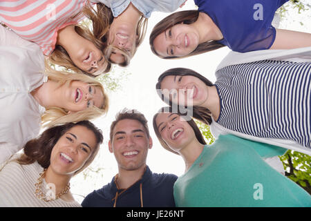 Happy smiling group of young friends staying together outdoor in the park Stock Photo