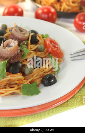 Spaghetti alla puttanesca mit Oliven, Kapern und Sardellen Stock Photo