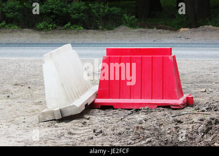 Red and white plastic barriers blocking the road Stock Photo