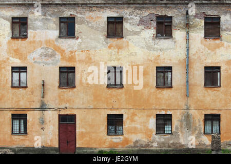 The texture of the old beige plaster and windows of the historic house. Stock Photo