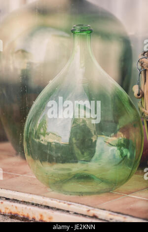 Old empty wine bottles behind the glass with street reflection Stock Photo