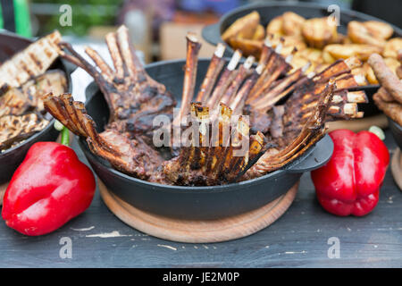 Roasted lamb rib chops with vegetables closeup, street food. Stock Photo