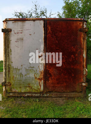 old closed destroyed rusty metal barrack in the garden Stock Photo