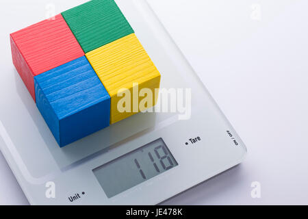 Digital kitchen scale with colorful cubes on it. Proper nutrition and ingredient control metaphor. Stock Photo