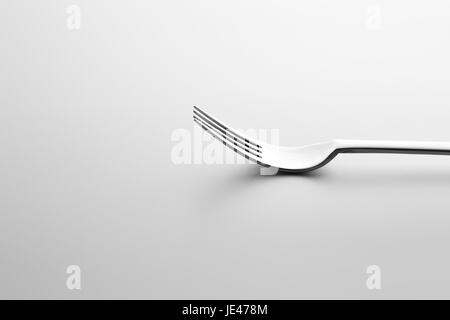 Close-up shot of metallic fork lying down on white surface. Minimalistic design photo. Stock Photo