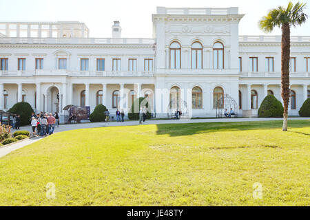 YALTA, RUSSIA - SEPTEMBER 28, 2014: tourists and front view of Grand Livadia Palace in Crimea. Livadia estate was summer residence of the Russian imperial family from 1860. Stock Photo