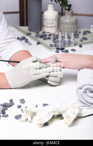 Closeup finger nail care by manicure specialist in beauty salon. Stock Photo