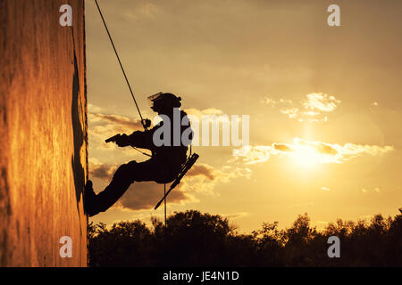 Silhouette of police officer during rope exercises with weapons Stock Photo