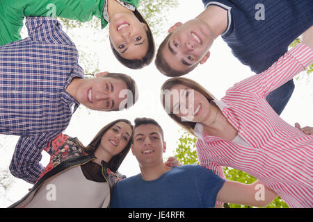 Happy smiling group of young friends staying together outdoor in the park Stock Photo