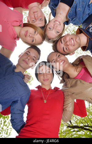 Happy smiling group of young friends staying together outdoor in the park Stock Photo