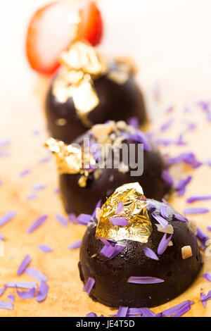 dark chocolate on a wooden table. Decorated with gold leaf. selective Focus Stock Photo