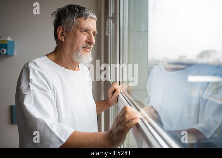 Patient at a hospital, looking from a window in his room, doing much better after the surgery Stock Photo