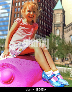 Young girl enjoying the greenspace and public art in downtown Cleveland, Ohio, USA. Stock Photo