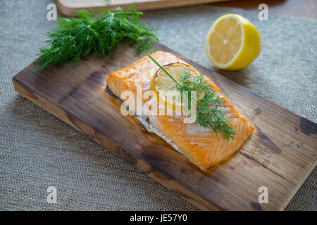 Fresh salmon on cedar plank with dill and lemon. Stock Photo