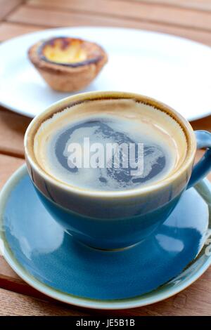 Black coffee with a Portuguese tart in the background Stock Photo