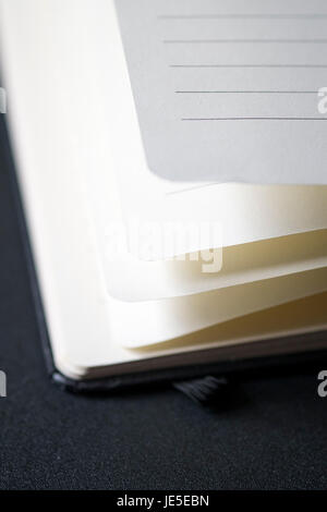 Opened business notepad with white sheets on the black desk Stock Photo