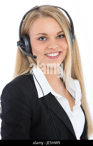 Eine junge symphatische Frau mit einem Headset lächelt in die Kamera. Sie verkörpert einen symphatischen und seriösen Callcenter-Agenten. Stock Photo