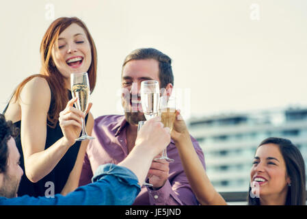 Friends drinking champagne together outdoors Stock Photo