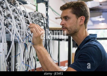 Electrician scrutinizing equipment Stock Photo