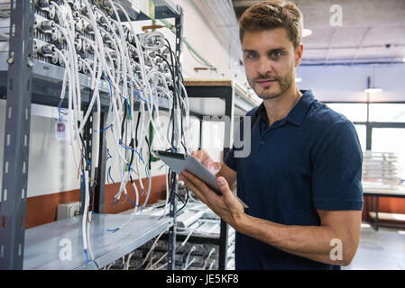 Electrical engineer using digital tablet in factory Stock Photo