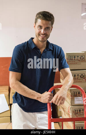 Man working in warehouse, smiling cheerfully, portrait Stock Photo