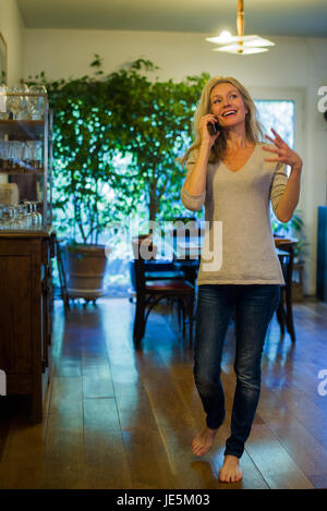 Woman talking on cell phone at home Stock Photo