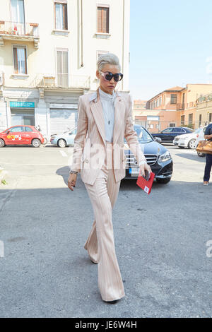 MILAN - JUNE 17: Esther Quek with pink striped suit before Diesel Black Gold fashion show, Milan Fashion Week street style on June 17, 2017 in Milan. Stock Photo